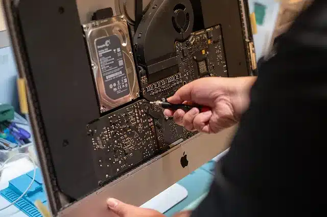 A computer technician replacing the LCD screen of an iMac